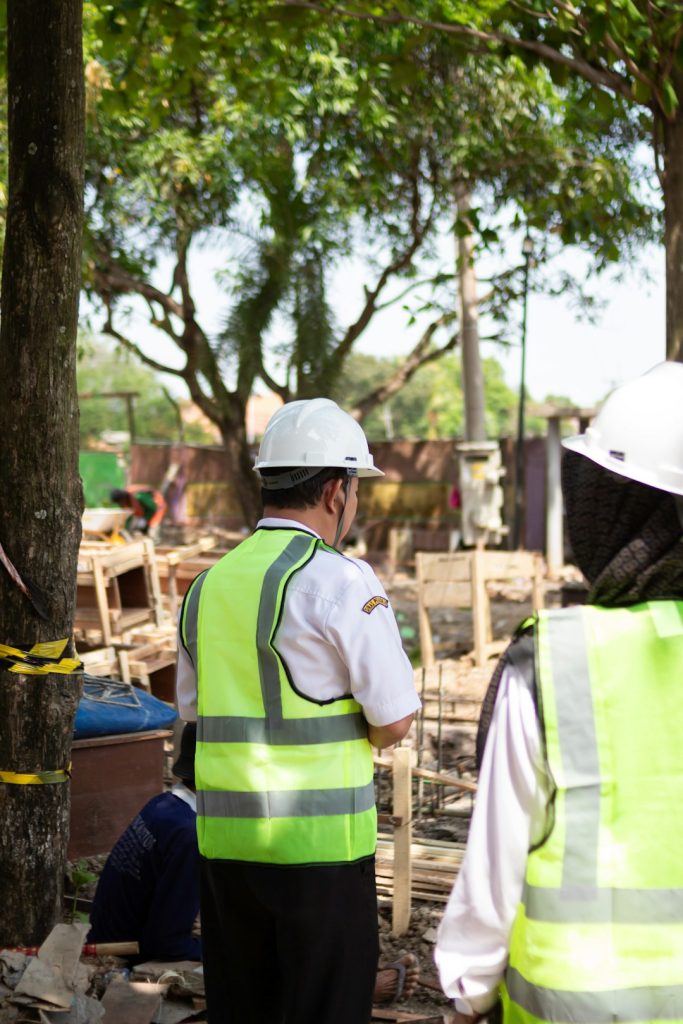 workers-in-hard-hats-and-safety-vests-at-construction-site-kjv2ie9nwgk